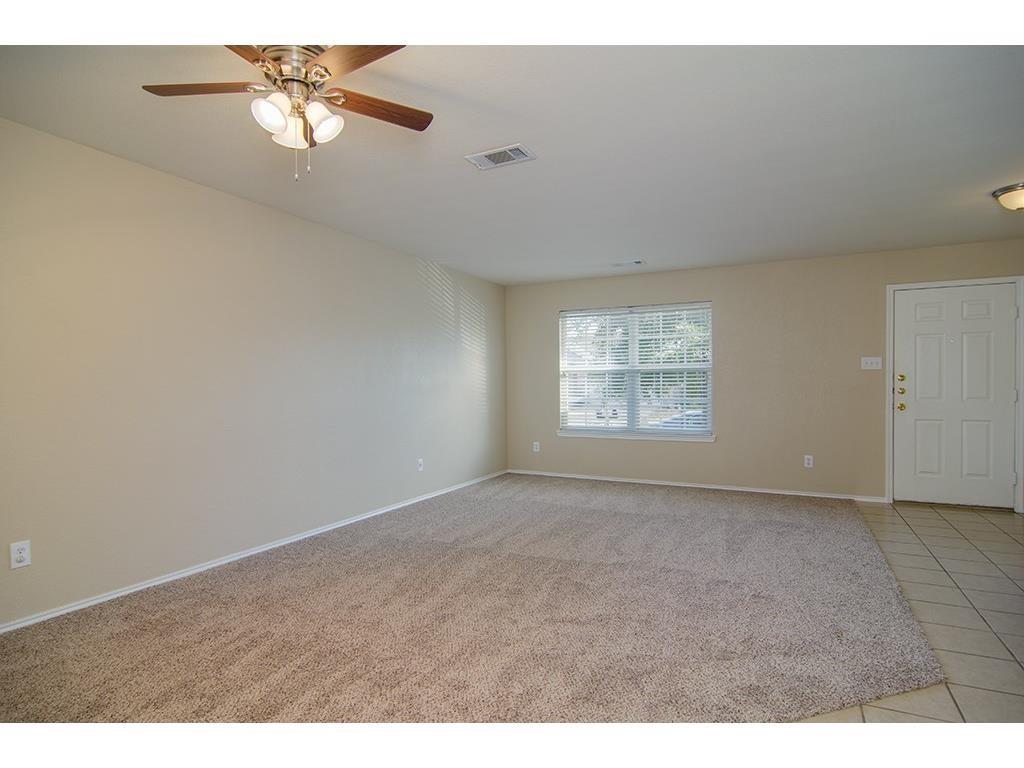 13109 Fieldstone Road Fort Worth, TX 76244 - Photo 12 of 25 Empty room with ceiling fan, light colored carpet, and light tile patterned floors