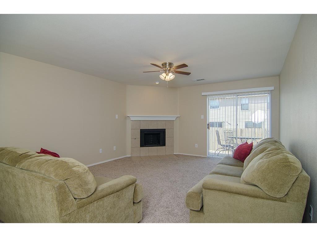 13109 Fieldstone Road Fort Worth, TX 76244 - Photo 14 of 25 Living room featuring carpet flooring, a tiled fireplace, and a ceiling fan