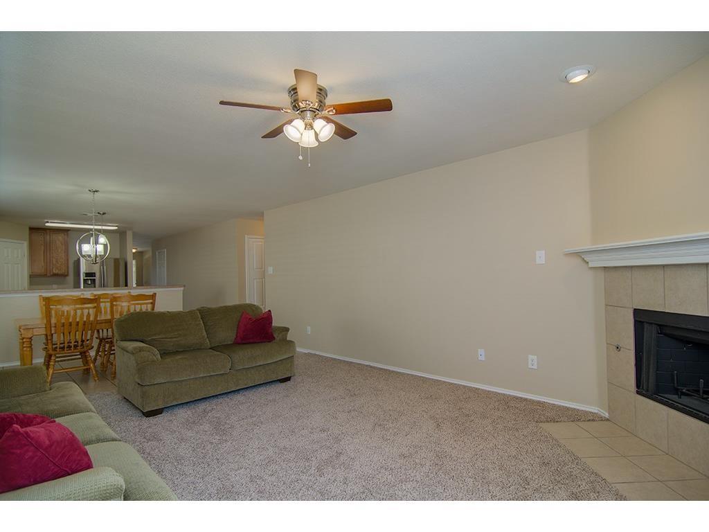 13109 Fieldstone Road Fort Worth, TX 76244 - Photo 15 of 25 Living area with ceiling fan, light colored carpet, and a tile fireplace