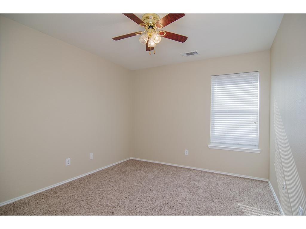 13109 Fieldstone Road Fort Worth, TX 76244 - Photo 4 of 25 Empty room with light carpet and a ceiling fan
