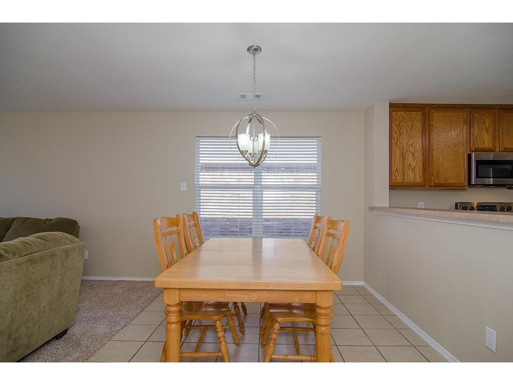 13109 Fieldstone Road Fort Worth, TX 76244 - Photo 7 of 25 Dining space with light tile patterned flooring and a chandelier