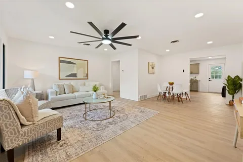 a living room with furniture and a wooden floor