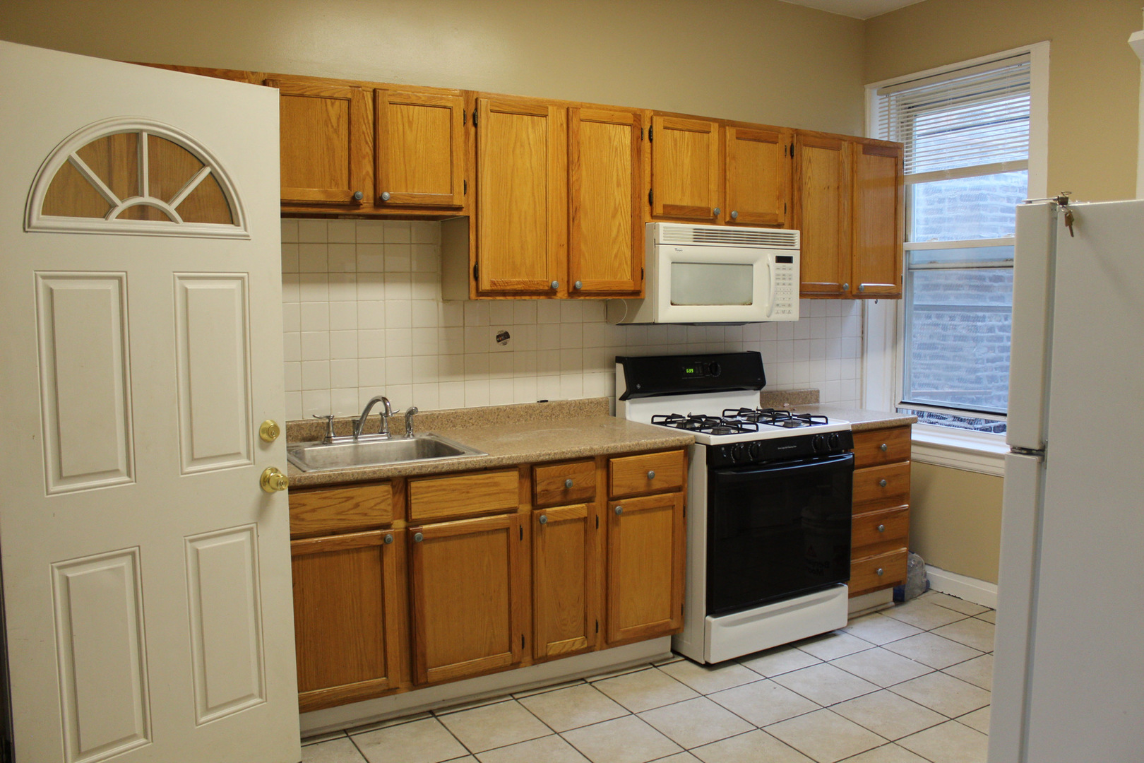 2252 West Cermak Road, Unit 2 Chicago, IL 60608 - Photo 4 of 10 a kitchen with stainless steel appliances granite countertop a stove a sink and a microwave