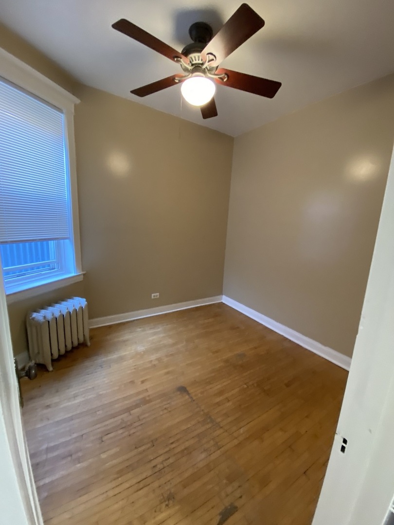 2252 West Cermak Road, Unit 2 Chicago, IL 60608 - Photo 5 of 10 an empty room with a ceiling fan and wooden floor
