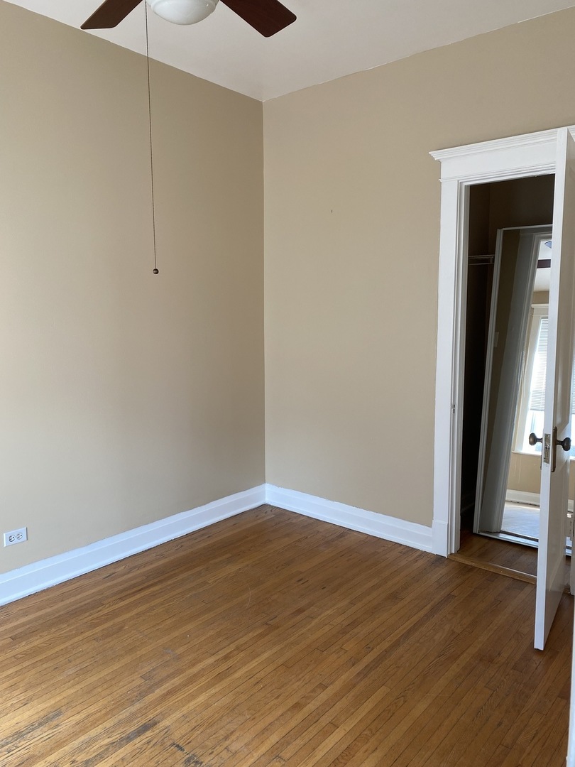 2252 West Cermak Road, Unit 2 Chicago, IL 60608 - Photo 8 of 10 a view of an empty room with wooden floor and a window