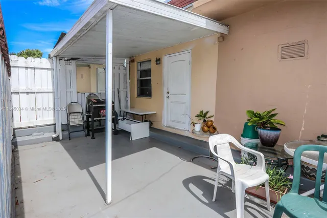 a view of a patio with table and chairs and potted plants