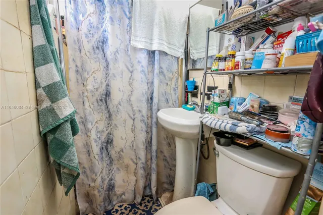 a bathroom with a sink toilet and shower curtain