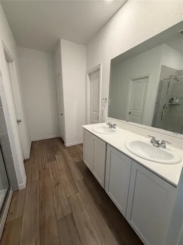 a bathroom with a sink a toilet a mirror and shower