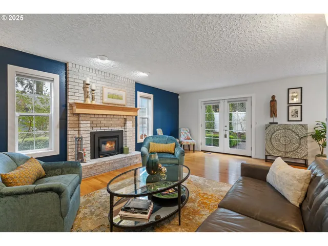 a living room with furniture large window and fireplace