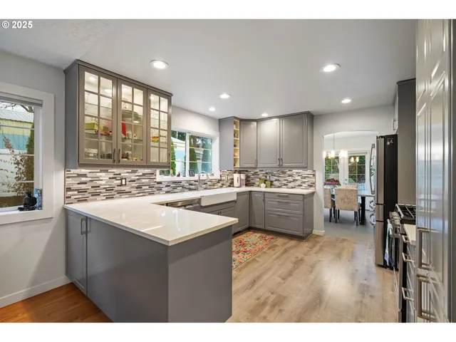 a kitchen with a sink cabinets a counter top space stainless steel appliances and a large window