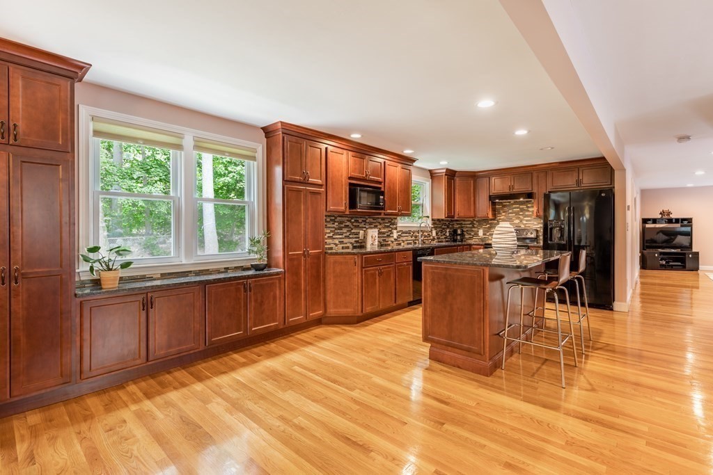 24 Oxbow Road Lexington, MA 02421 - Photo 4 of 28 a kitchen with stainless steel appliances granite countertop a stove a sink a oven with a dining table and chairs