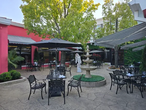 a view of a patio with a dining table and chairs under an umbrella