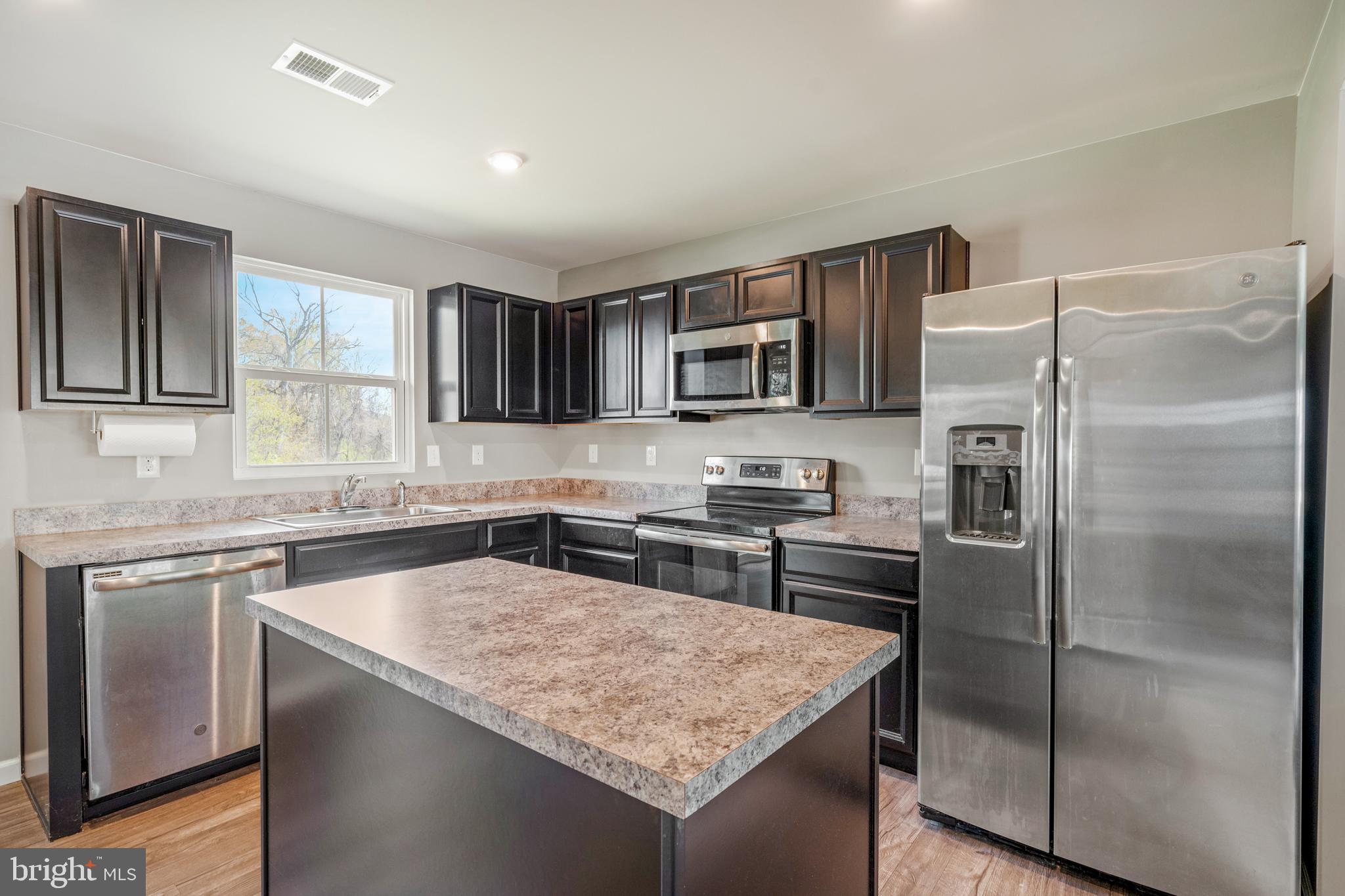 141 Wye Oak Drive Townsend, DE 19734 - Photo 9 of 32 a kitchen with kitchen island a counter top space cabinets stainless steel appliances and a window