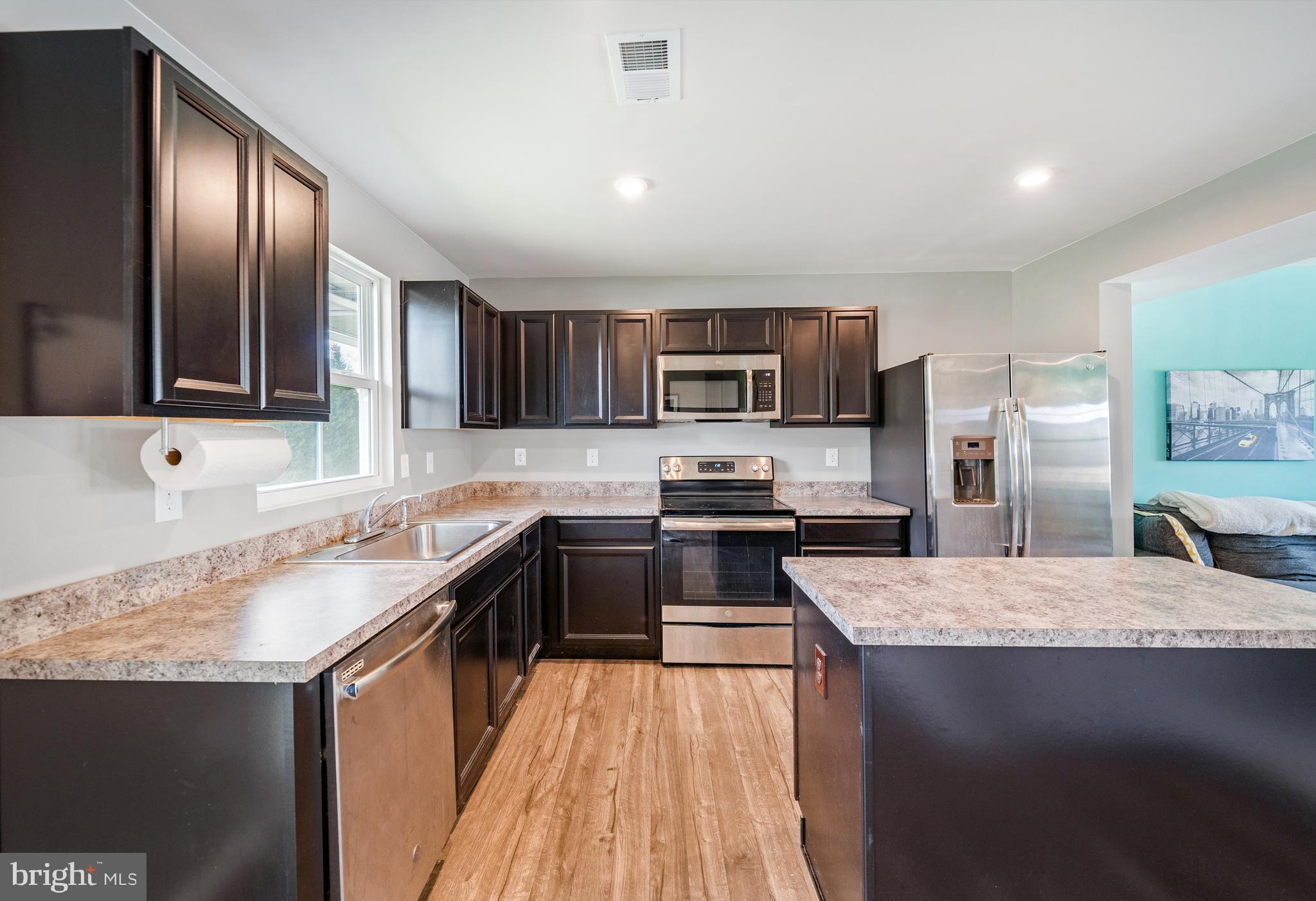 141 Wye Oak Drive Townsend, DE 19734 - Photo 10 of 32 a kitchen with stainless steel appliances granite countertop a sink stove microwave and refrigerator