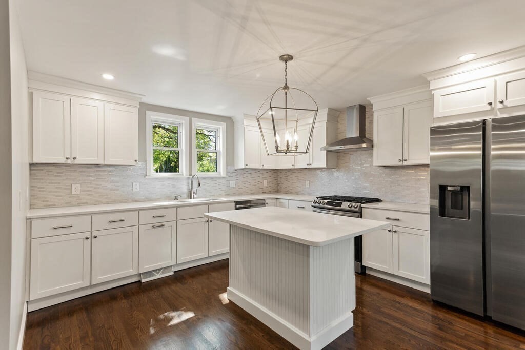 48 Pinewood Avenue Billerica, MA 01821 - Photo 12 of 26 a kitchen with stainless steel appliances granite countertop a stove a sink dishwasher a refrigerator white cabinets and wooden floor