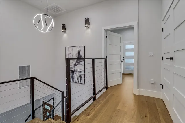 a view of a hallway with wooden floor and staircase