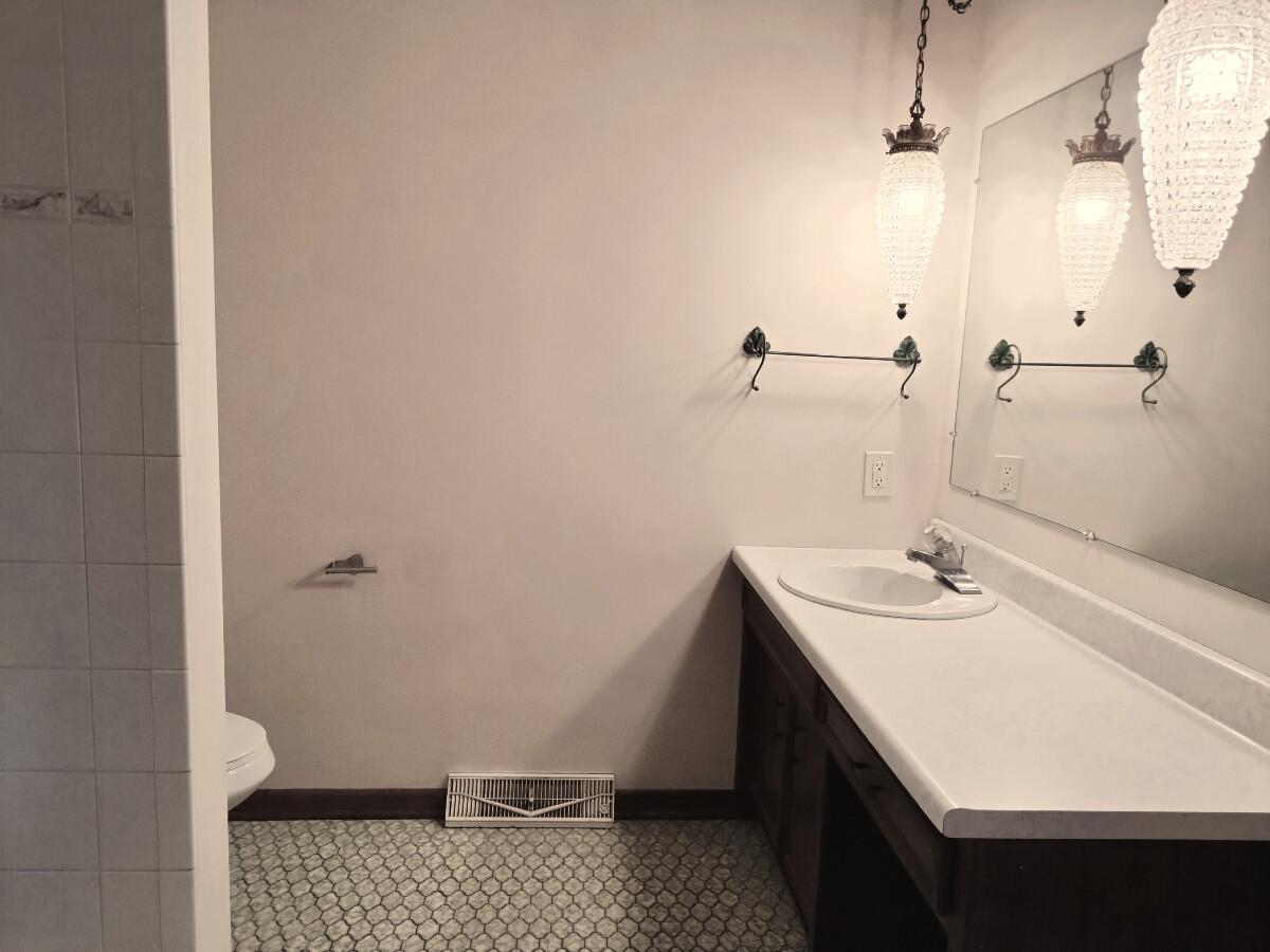 1040 Azalea Drive Munster, IN 46321 - Photo 9 of 16 a bathroom with a sink a toilet a shower and a mirror