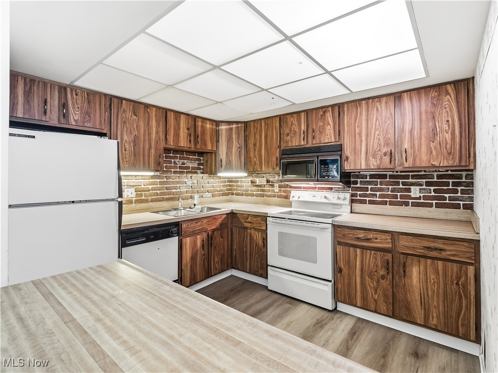 22968 Maple Ridge Road, Unit 103 North Olmsted, OH 44070 - Photo 9 of 25 Kitchen with white appliances, light countertops, and decorative backsplash