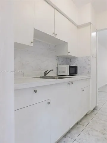 a kitchen with white cabinets and white appliances
