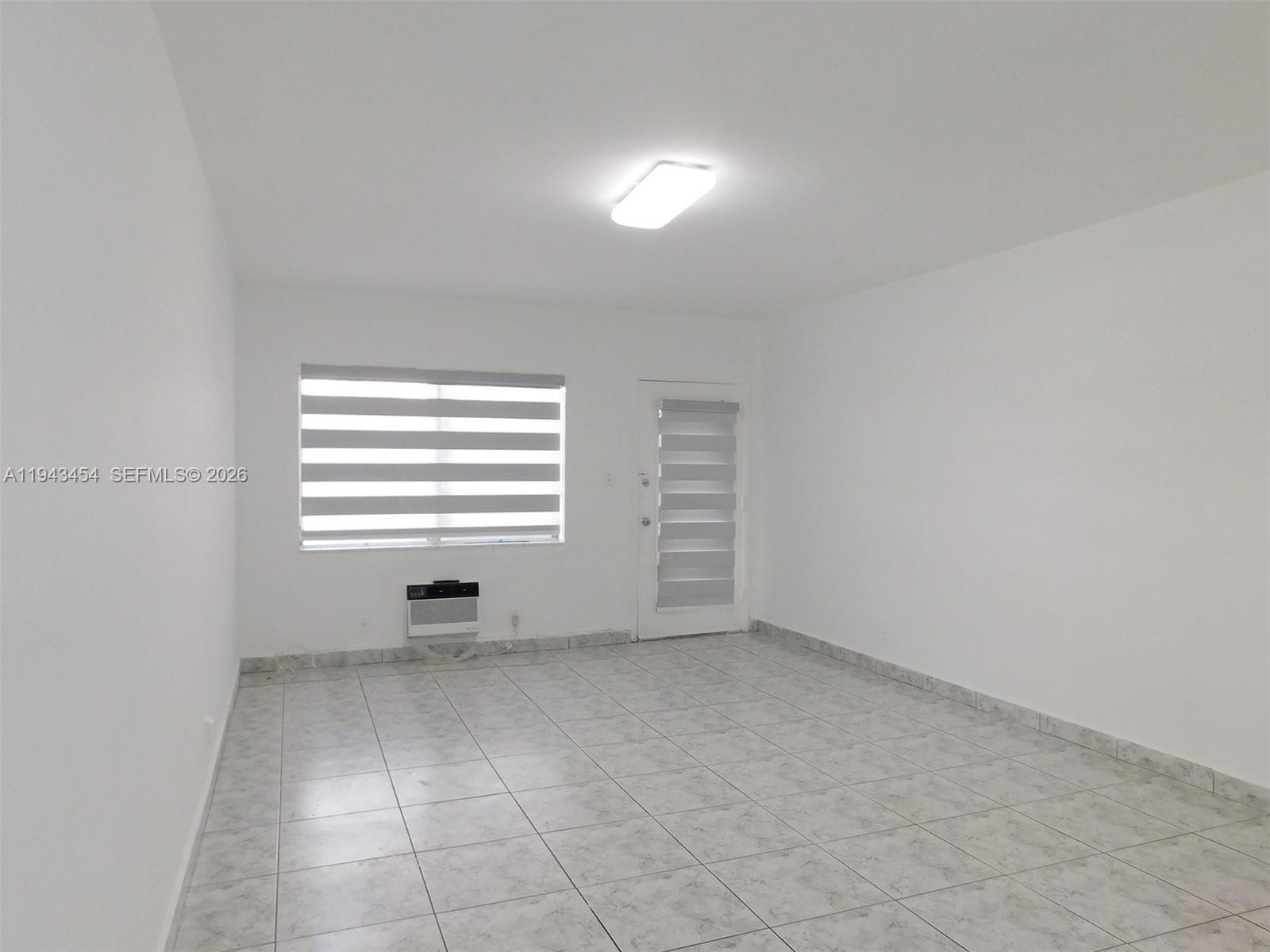 7840 Harding Avenue, Unit 2 Miami Beach, FL 33141 - Photo 7 of 19 an empty room with windows