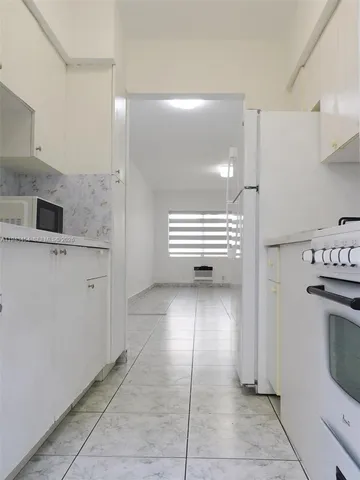 a view of kitchen with refrigerator and cabinets