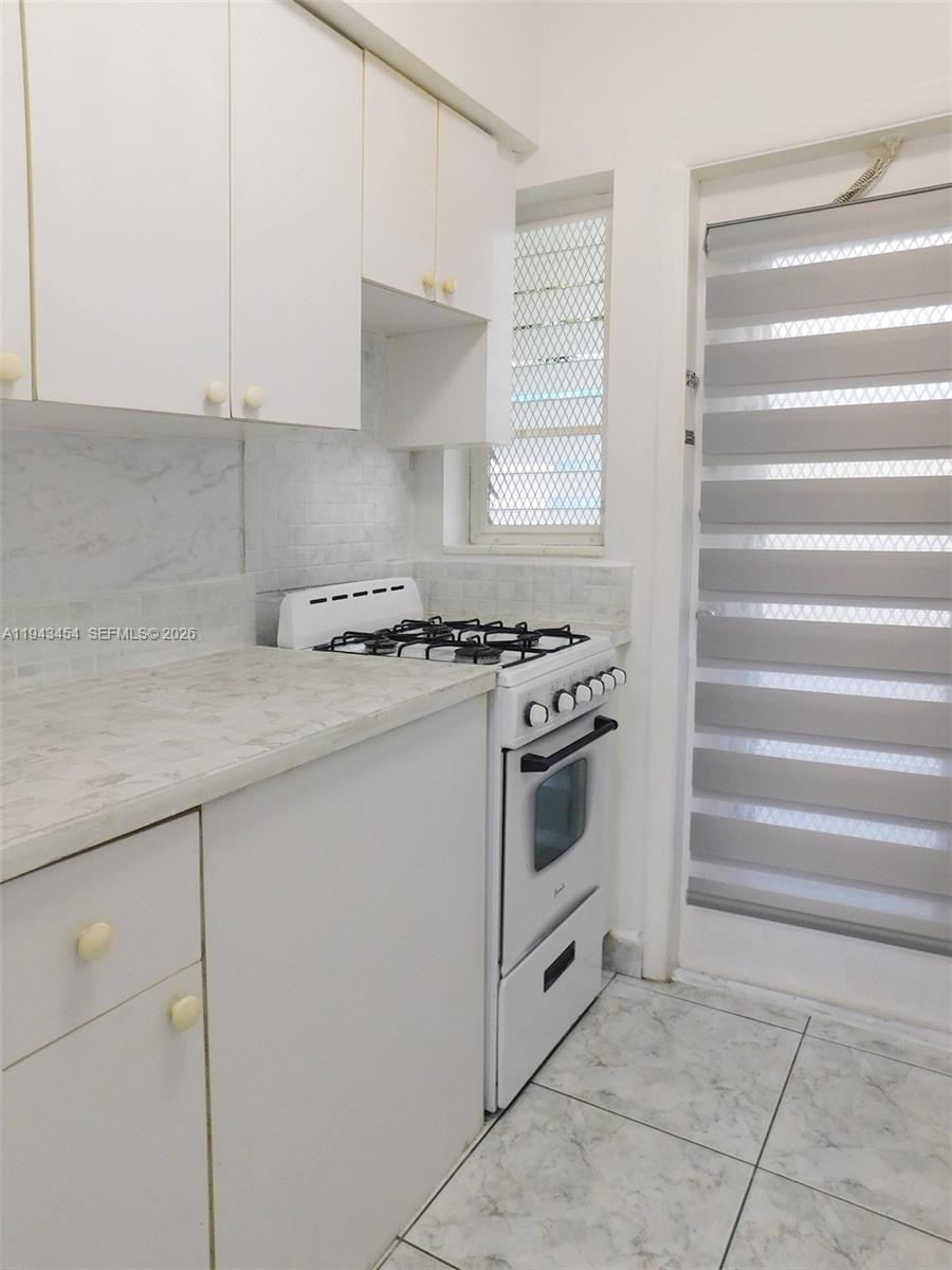 7840 Harding Avenue, Unit 2 Miami Beach, FL 33141 - Photo 10 of 19 a kitchen with granite countertop a stove and a sink