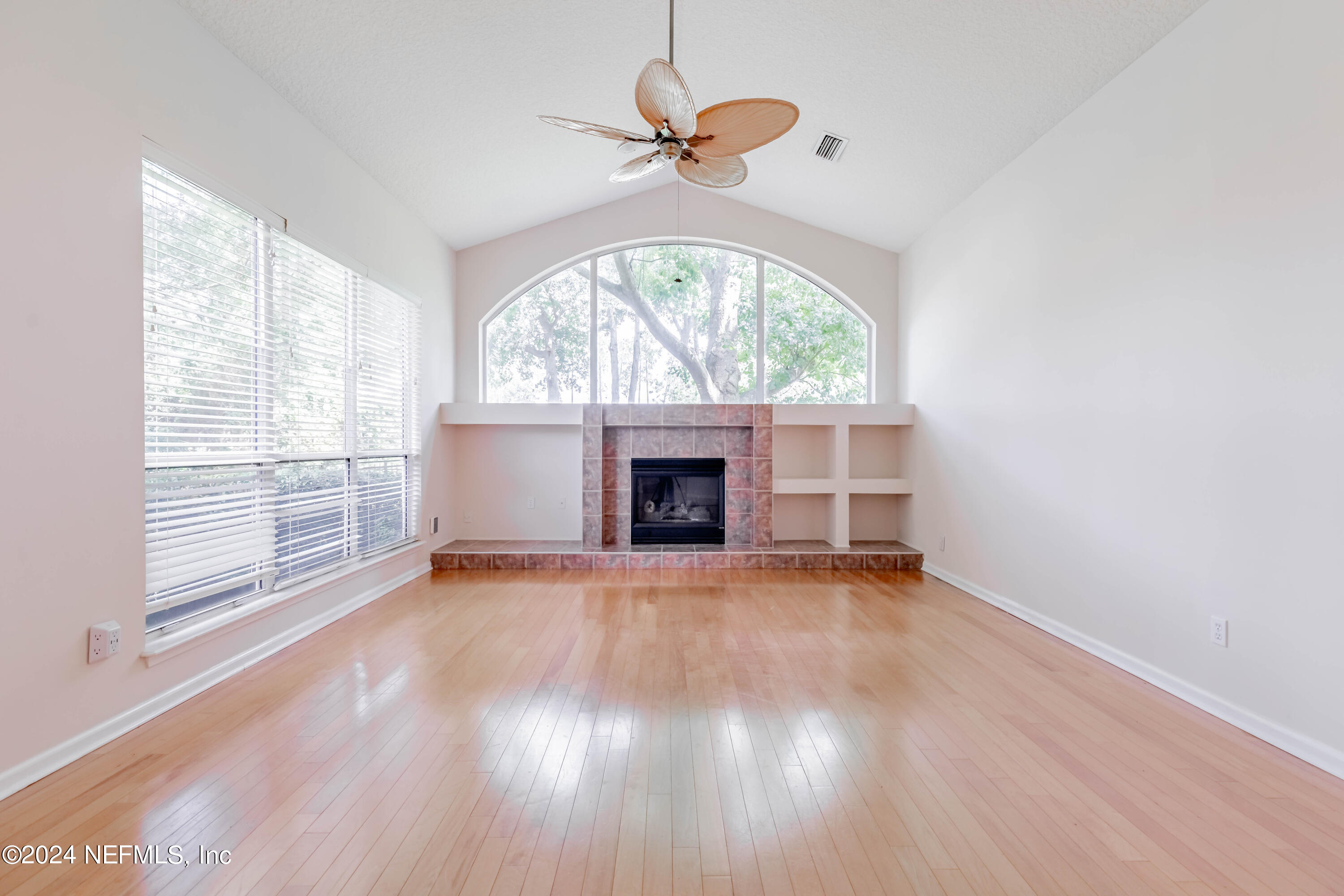 2285 Eagle Harbor Parkway Fleming Island, FL 32003 - Photo 6 of 59 an empty room with wooden floor a chandelier fan and windows