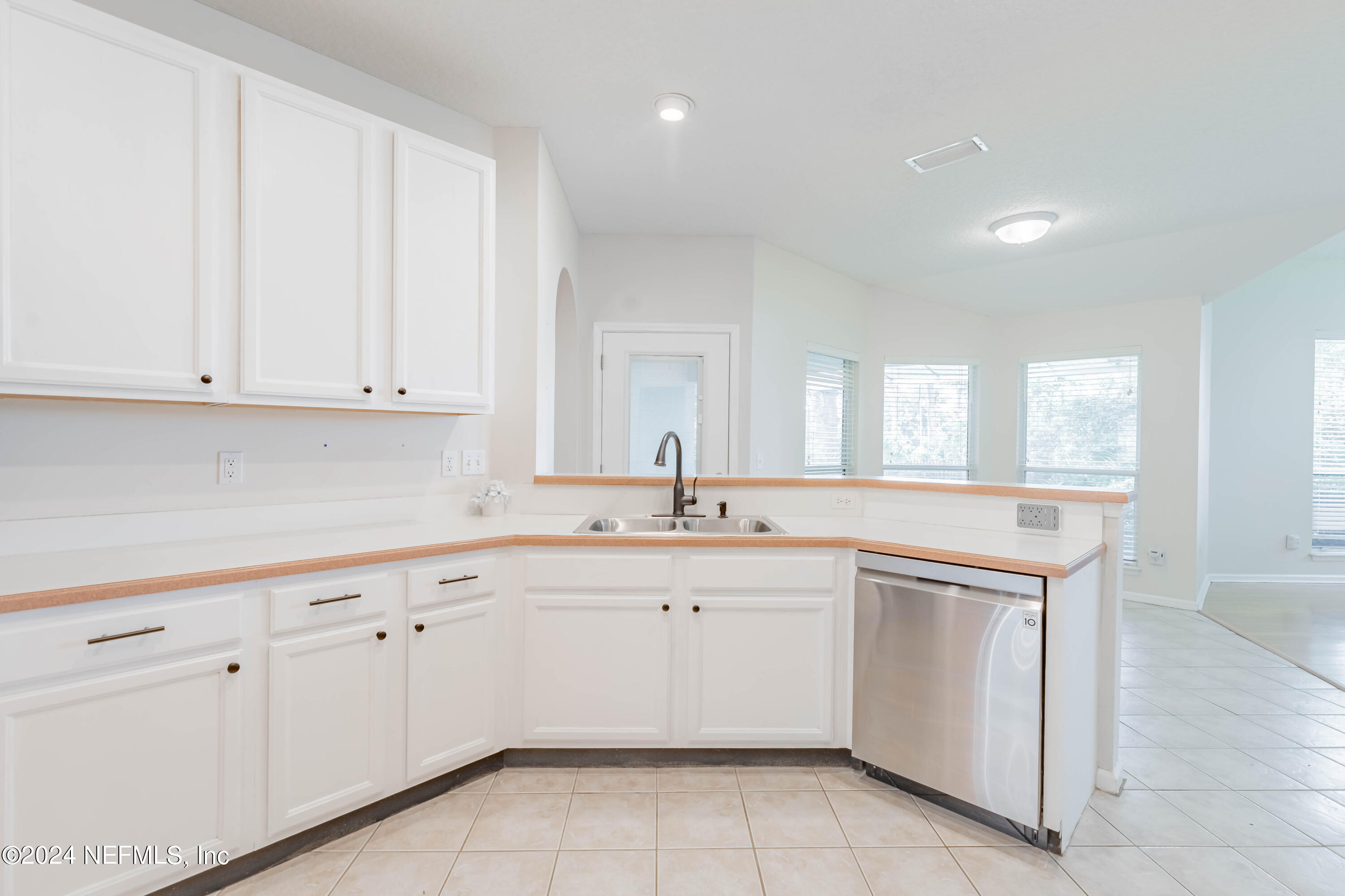 2285 Eagle Harbor Parkway Fleming Island, FL 32003 - Photo 8 of 59 a kitchen with white cabinets appliances a sink and a window