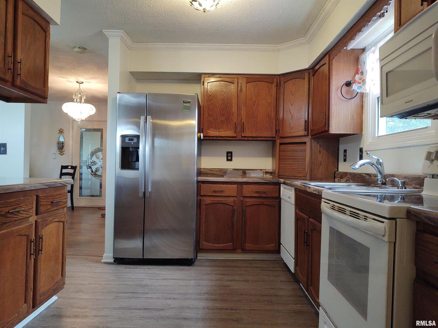 110 Stork Street Anna, IL 62906 - Photo 7 of 27 a kitchen with stainless steel appliances granite countertop a refrigerator a sink dishwasher a stove with wooden cabinets and floor