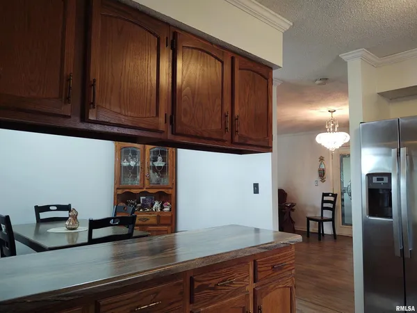 a kitchen with stainless steel appliances granite countertop a refrigerator a stove and a sink with wooden cabinets