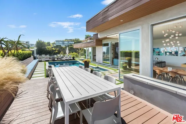 a view of a patio with table and chairs with wooden floor and fence