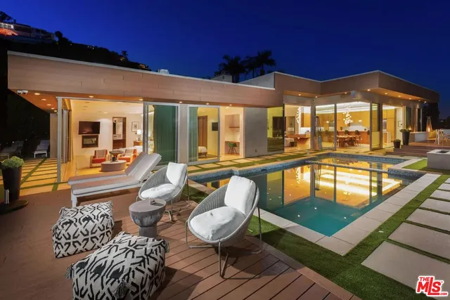 a view of a patio with couches table and chairs with wooden floor and fence