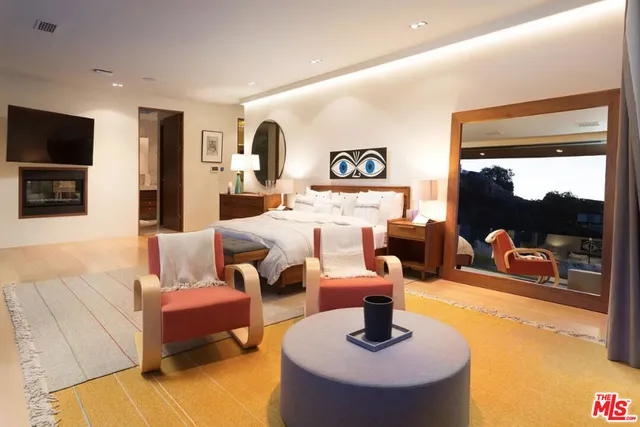 a room with a bed and large windows