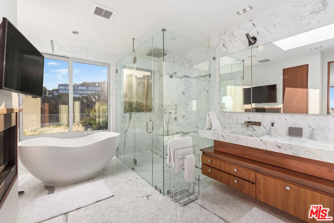 1429 Devlin Drive Los Angeles, CA 90069 - Photo 57 of 58 a spacious bathroom with a bathtub sink and mirror