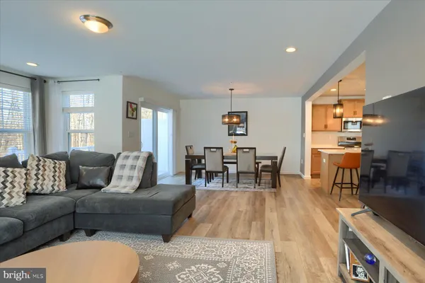 a living room with furniture and a dining table with kitchen view