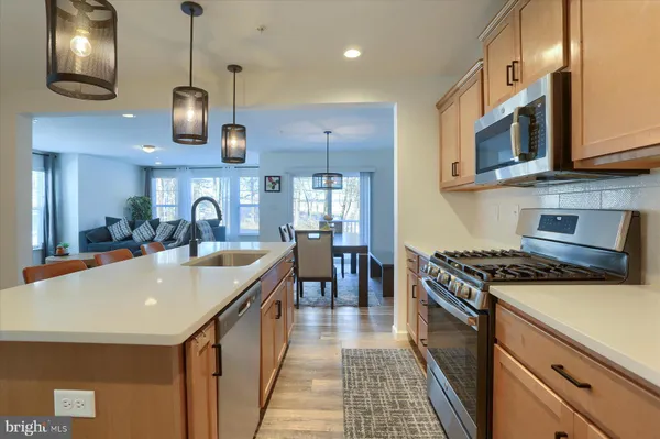 a kitchen with stainless steel appliances granite countertop a sink a stove and a refrigerator