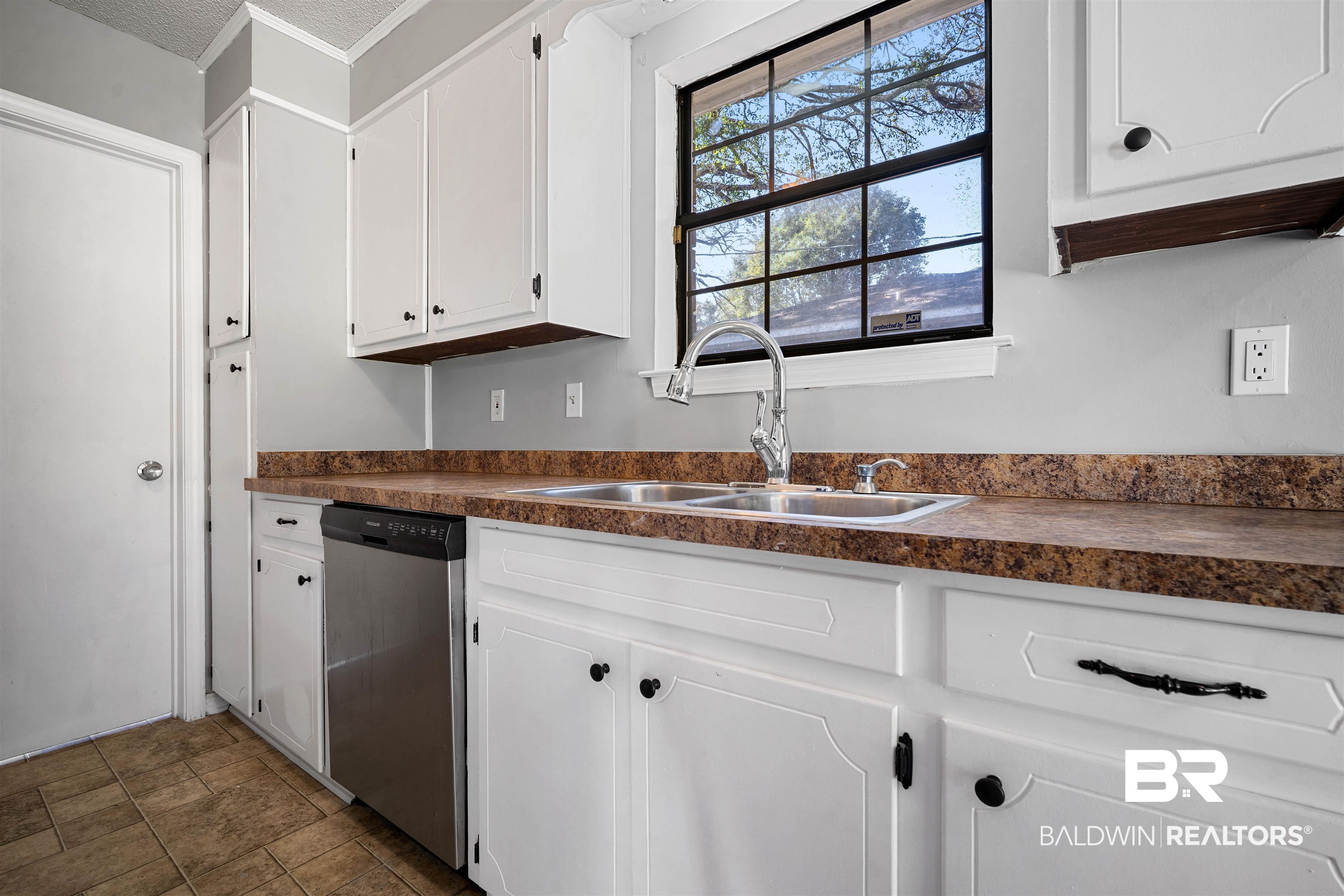 12910 Del Rio Street Grand Bay, AL 36541 - Photo 10 of 26 Kitchen with dark countertops, white cabinets, and stainless steel dishwasher