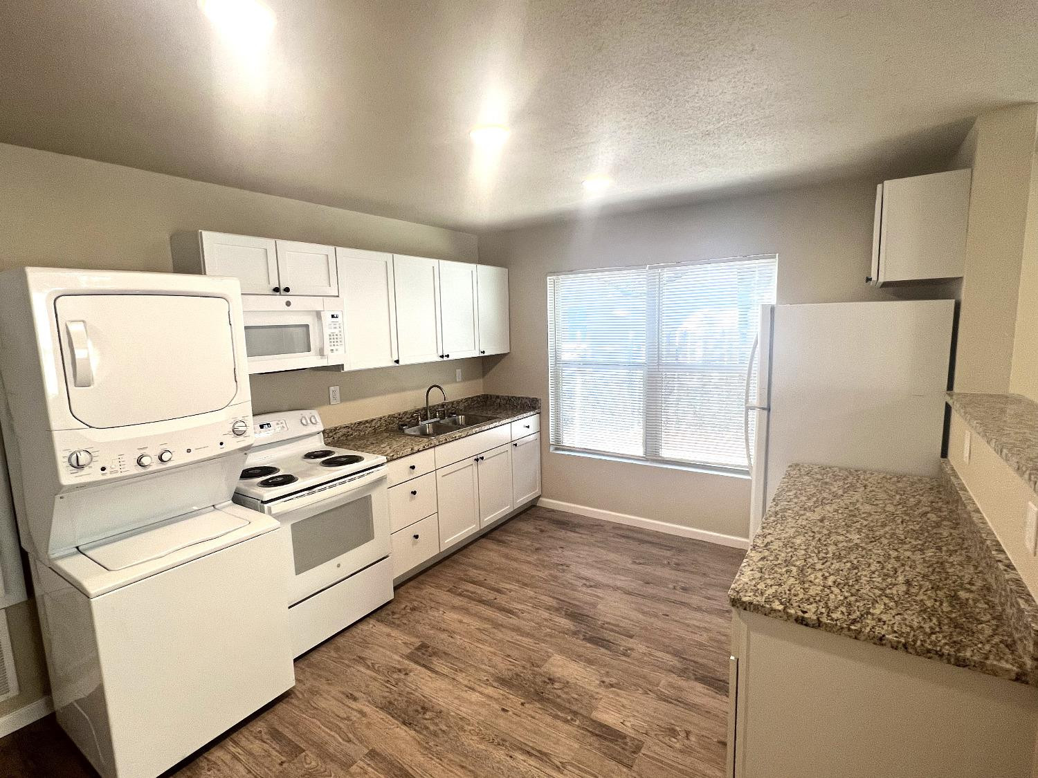 1904 17th Street, Unit A Lubbock, TX 79401 - Photo 3 of 12 a kitchen with a stove a sink and a refrigerator