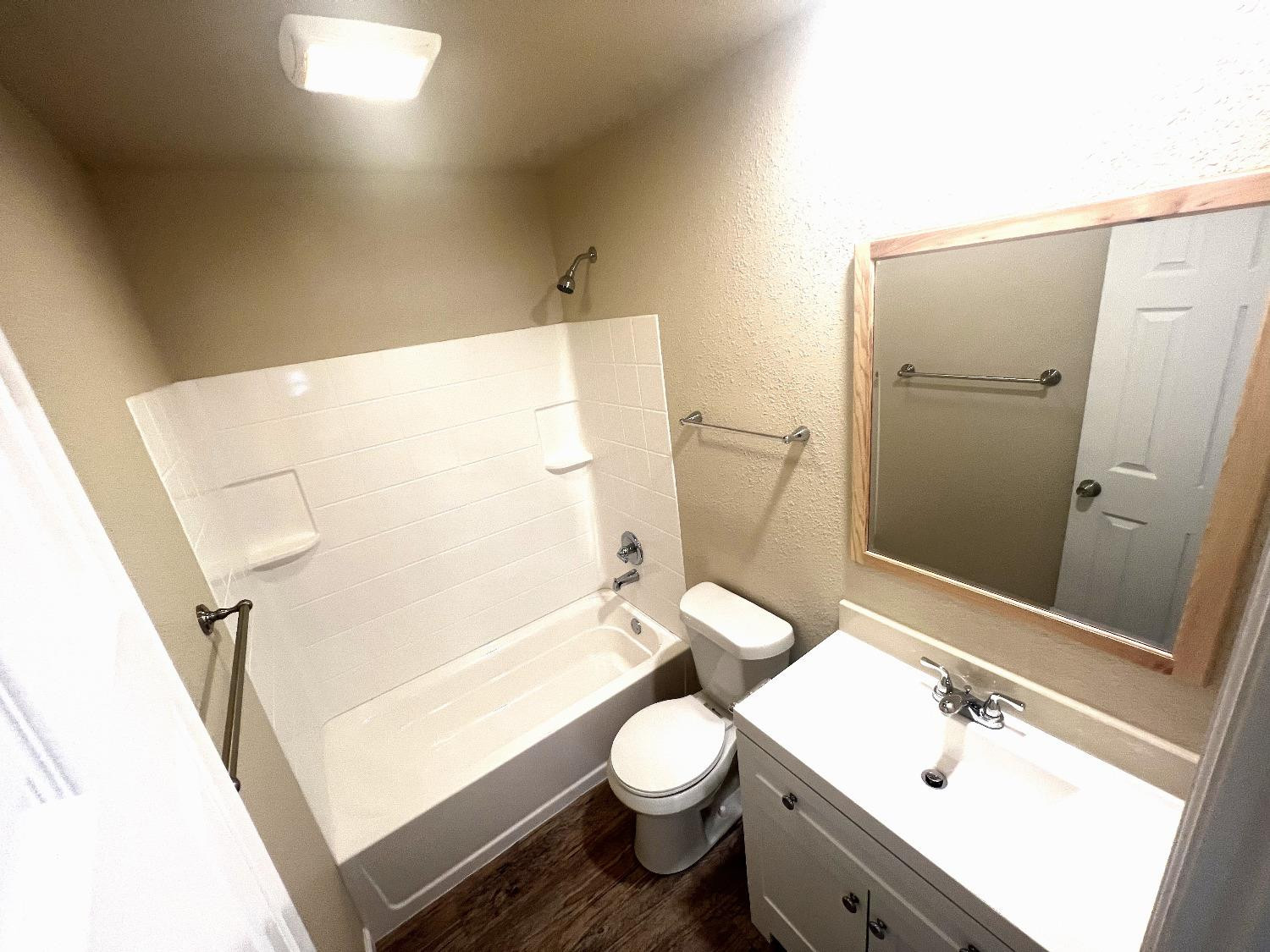 1904 17th Street, Unit A Lubbock, TX 79401 - Photo 6 of 12 a bathroom with a sink a toilet and shower a mirror
