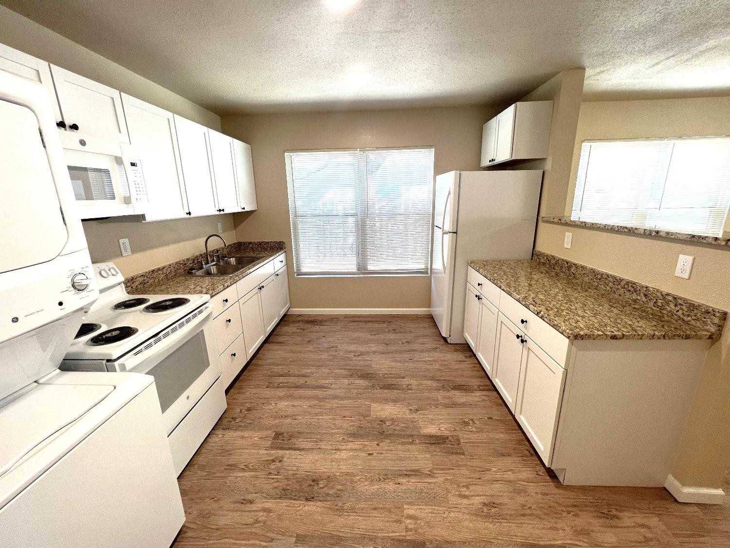 1904 17th Street, Unit A Lubbock, TX 79401 - Photo 8 of 12 a large kitchen with stainless steel appliances granite countertop a stove a sink and a refrigerator