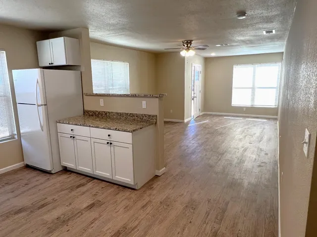 a kitchen with a refrigerator sink and cabinets
