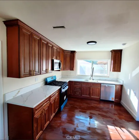 a kitchen with counter top space and wooden floor