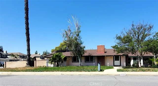 a front view of a house with a garden and plants