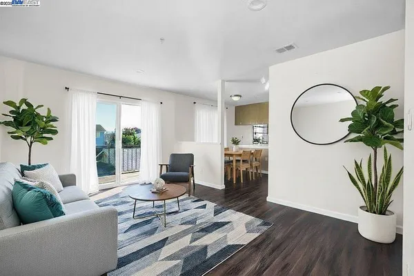 a living room with furniture a window and a potted plant