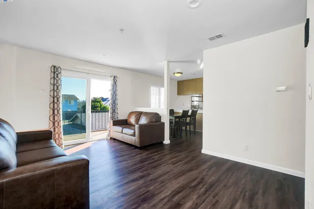 a kitchen with granite countertop white cabinets and wooden floor