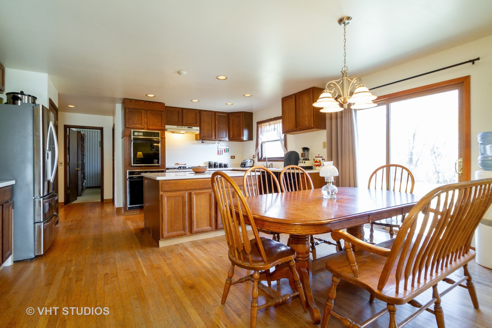 6514 Johnson Road Hebron, IL 60034 - Photo 7 of 17 an open kitchen with dining table and stainless steel appliances