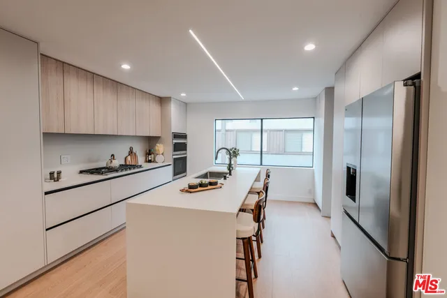 a kitchen with stainless steel appliances a refrigerator sink and cabinets