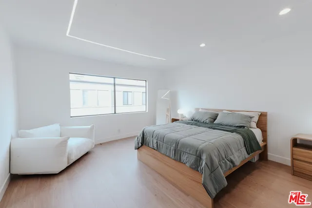 a view of a fountain in front of a brick house with large trees