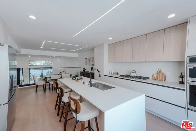 a kitchen with a dining table chairs refrigerator and cabinets