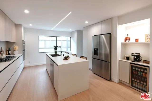 a kitchen with stainless steel appliances a sink and a refrigerator